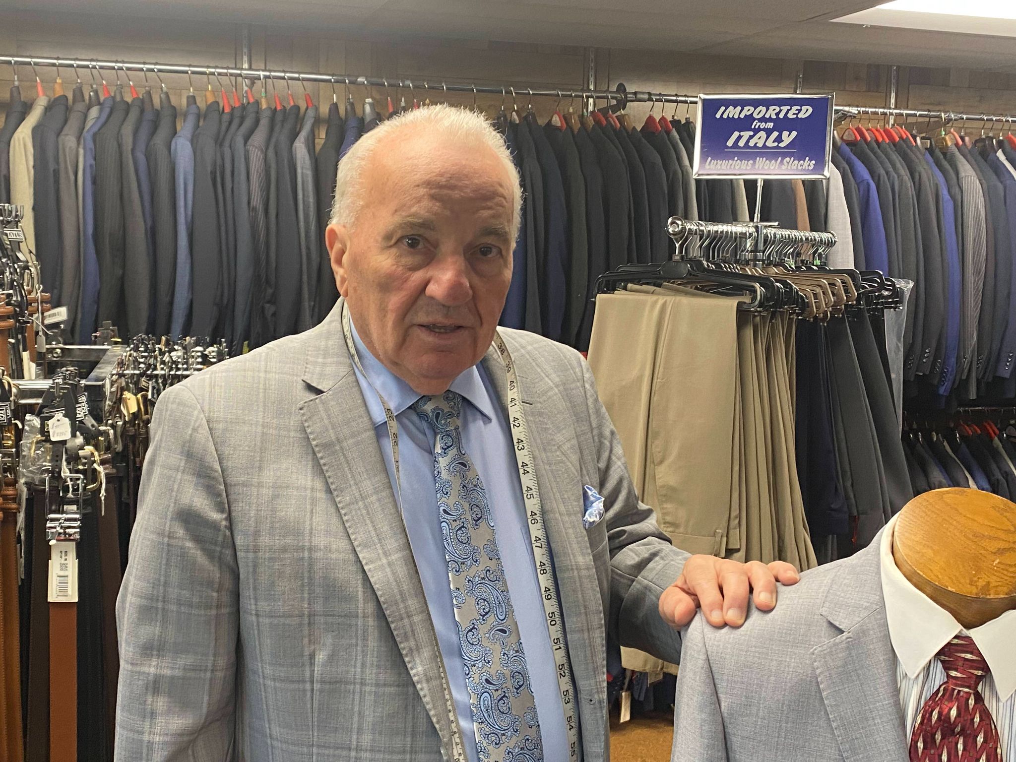 Ostuni clothier standing beside a tailored suit